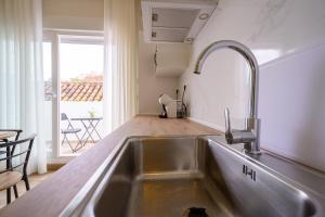 a kitchen with a stainless steel sink and a table at Hotel Boutique Alcazaba Salobreña in Salobreña +71 photos