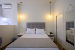 a bedroom with a large bed with white pillows at Hotel Boutique Alcazaba Salobreña in Salobreña