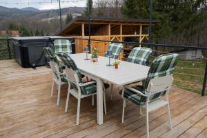 a white table and chairs on a deck at Exclusive Dome Valea Doftanei in Trăisteni