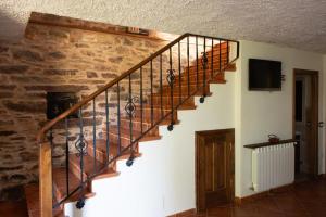 a wooden staircase in a room with a stone wall at Casa rural osvilares in Santiago de Compostela