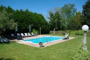 a swimming pool in a yard with chairs around it at Casa rural osvilares in Santiago de Compostela