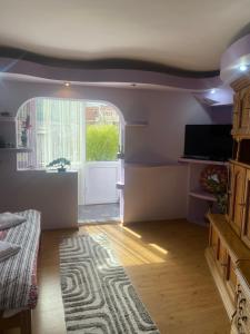 a living room with a large window and a couch at Central Home in Piatra Neamţ