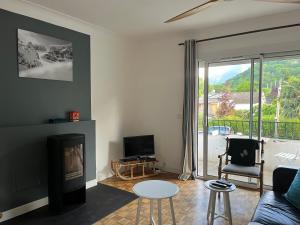a living room with a couch and a fire place at Villa de charme jardin vue sur montagnes rénovation 2026 in Argelès-Gazost
