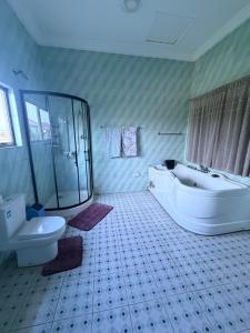 a bathroom with a shower and a tub and a toilet at Afranasa Inn in Tema +28 photos