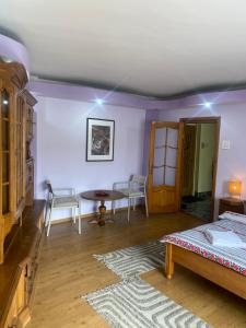 a bedroom with a bed and a table and chairs at Central Home in Piatra Neamţ