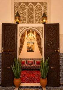 a room with two potted plants and a chandelier at RIAD YOUSSEF in Fez