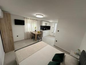 a room with a bed and a kitchen with a table at Apartment Bonaca in Posedarje