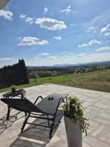 a table and a chair on a patio with a view at Apartament Królówka in Nowy Wiśnicz +6 photos