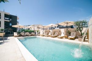 a swimming pool with chairs and umbrellas on a building at Boutique Hotel Zara in Ulcinj