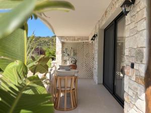 a patio of a house with a table and chairs at Noima Kalamitsi Boutique Studios in Kalamitsi