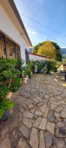 a stone patio with plants in front of a building at Contos de Alice Quartos in Tiradentes
