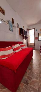 a red bed with pillows on it in a room at Contos de Alice Quartos in Tiradentes +9 photos