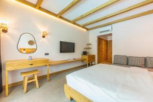 a bedroom with a bed and a desk and a television at The Pearl Ölüdeniz in Oludeniz