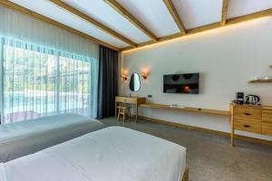 a hotel room with two beds and a tv at The Pearl Ölüdeniz in Oludeniz +105 photos