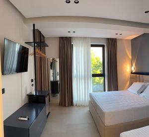 a hotel room with a bed and a window at Hotel Kloi - Rooms & Jacuzzi Vlore in Vlorë