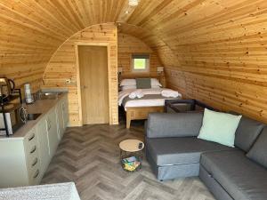 a room with a couch and a bed in a cabin at Milldown Glamping in Coldingham