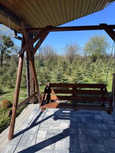 a wooden bench sitting on top of a porch at Domek na wzgórzu in Ukta