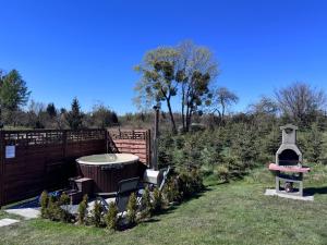 a garden with a hot tub in the grass at Domek na wzgórzu in Ukta