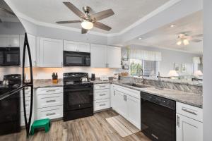 a kitchen with white cabinets and a ceiling fan at 4104 - Sever's Hideaway in Duck