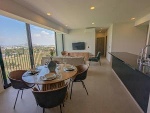a dining room with a table and chairs and a kitchen at (Luxury Apartment en Punto Sur in Los Gavilanes
