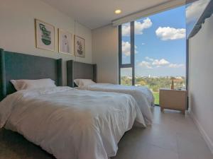 a bedroom with two beds and a large window at (Luxury Apartment en Punto Sur in Los Gavilanes