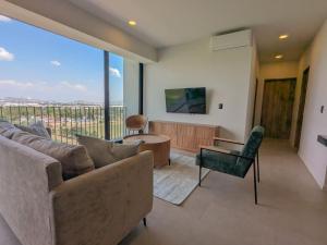 a living room with a couch and a tv at (Luxury Apartment en Punto Sur in Los Gavilanes