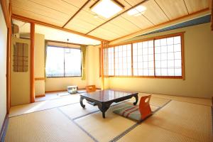 野沢温泉村にある中島屋旅館のテーブルと椅子2脚のあるリビングルーム