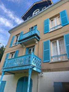 a blue balcony on the side of a building at La maison de Blandine in Honfleur