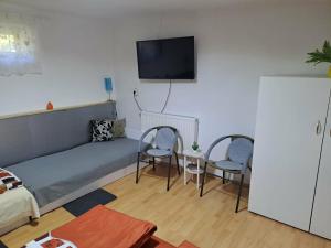 a living room with a couch and two chairs at Kisfaludy Vendégház in Abádszalók