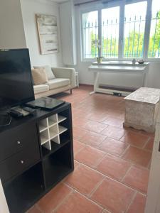 a living room with a flat screen tv and a couch at La maison de Blandine in Honfleur