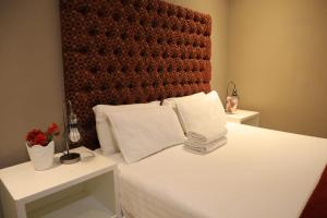 a bed with two white pillows and a red headboard at Guesthouse Gabby in Klerksdorp