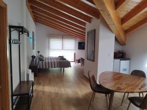 a living room with a table and a bed at RINCON DE MUTILOA Balcón del Aitzgorri HabTuristica in Mutiloa