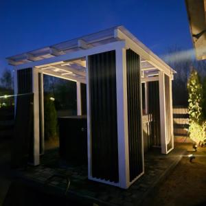 a pergola sitting on a patio at night at Domek na Roztoczu - Jacuzzi in Krasnobród +4 photos