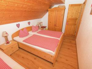 ein Schlafzimmer mit einem Holzbett und roten und weißen Kissen in der Unterkunft Alluring Holiday Home in Ubersee with Whirlpool in Übersee