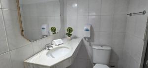 ein Badezimmer mit Waschbecken, Toilette und Spiegel in der Unterkunft Nuevo Hotel in Rivera + 79 Fotos