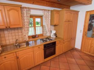 eine Küche mit Holzschränken und einer Spüle in der Unterkunft Alluring Holiday Home in Ubersee with Whirlpool in Übersee