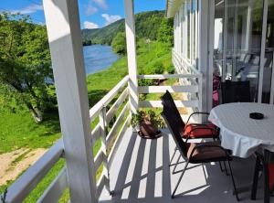 a porch with a white fence and a table and chairs at Rooms Đenadija in Hrvatska Kostajnica