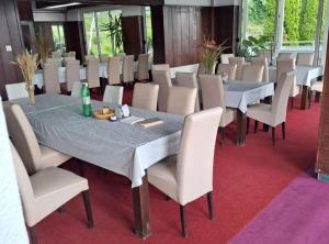a dining room with white tables and chairs at Rooms Đenadija in Hrvatska Kostajnica