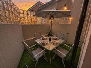 a dining room table with chairs and an umbrella at Cc House Gaia 2 in Vila Nova de Gaia