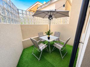 a table and chairs with an umbrella on a balcony at Cc House Gaia 2 in Vila Nova de Gaia