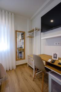 a room with a desk and a table and a mirror at Hotel Boutique Alcazaba Salobreña in Salobreña