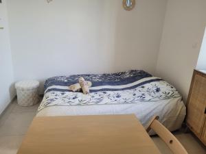 a small bed in a room with a table at Le cocon de Suze in Suze-la-Rousse