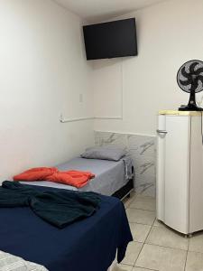 a bedroom with two beds and a flat screen tv at Hospedagem Aconchego in Lagoa Santa