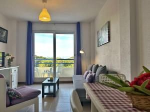 a living room with a couch and a table and a window at Duplex con vistas La Arena 4605 in Arnuero