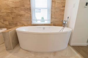 a white bath tub in a bathroom with a window at Whispering Swan Bay Haven in Trenton +26 photos