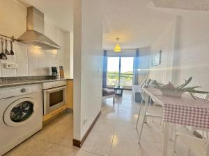 a kitchen with a washing machine and a table with chairs at Duplex con vistas La Arena 4605 in Arnuero