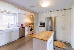 a kitchen with white cabinets and a stainless steel refrigerator at Whispering Swan Bay Haven in Trenton