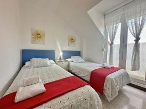 a bedroom with two beds and a window at Duplex con vistas La Arena 4605 in Arnuero +30 photos