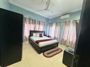 a bedroom with a bed and some windows at Afranasa Inn in Tema