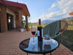a bottle of wine and a glass on a table at Villa Lazarina Vineyard Views in Kvareli +68 photos